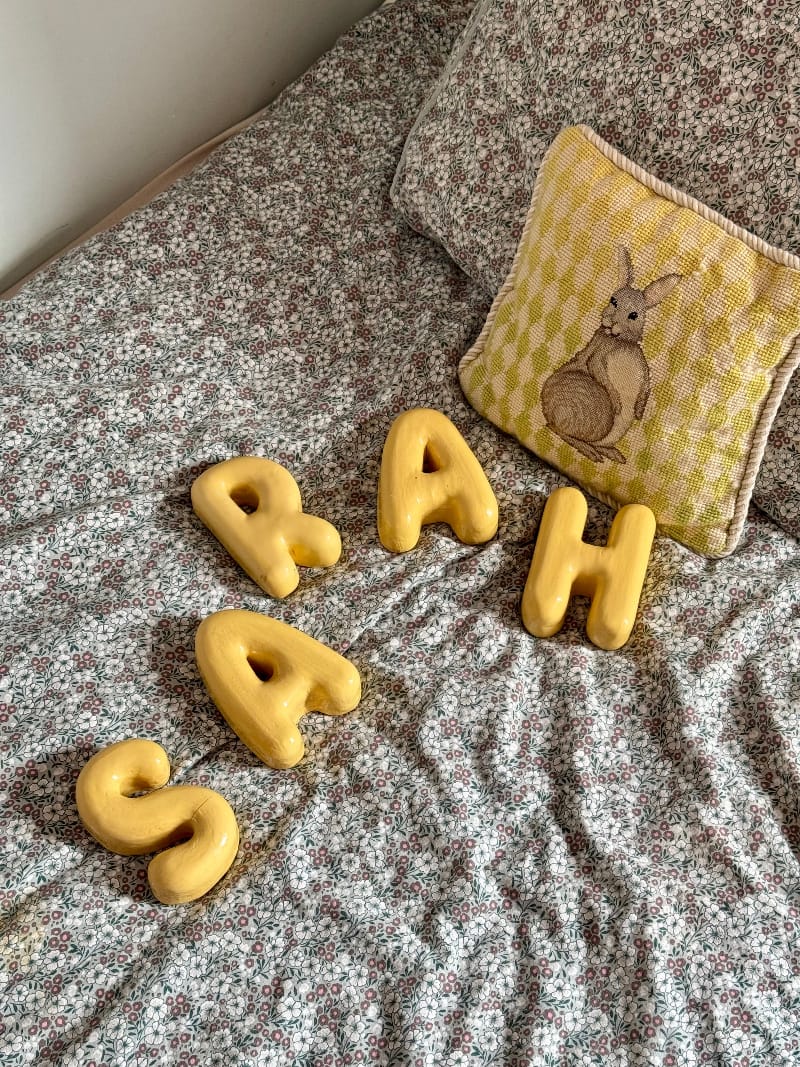 Yellow ceramic letters spelling &