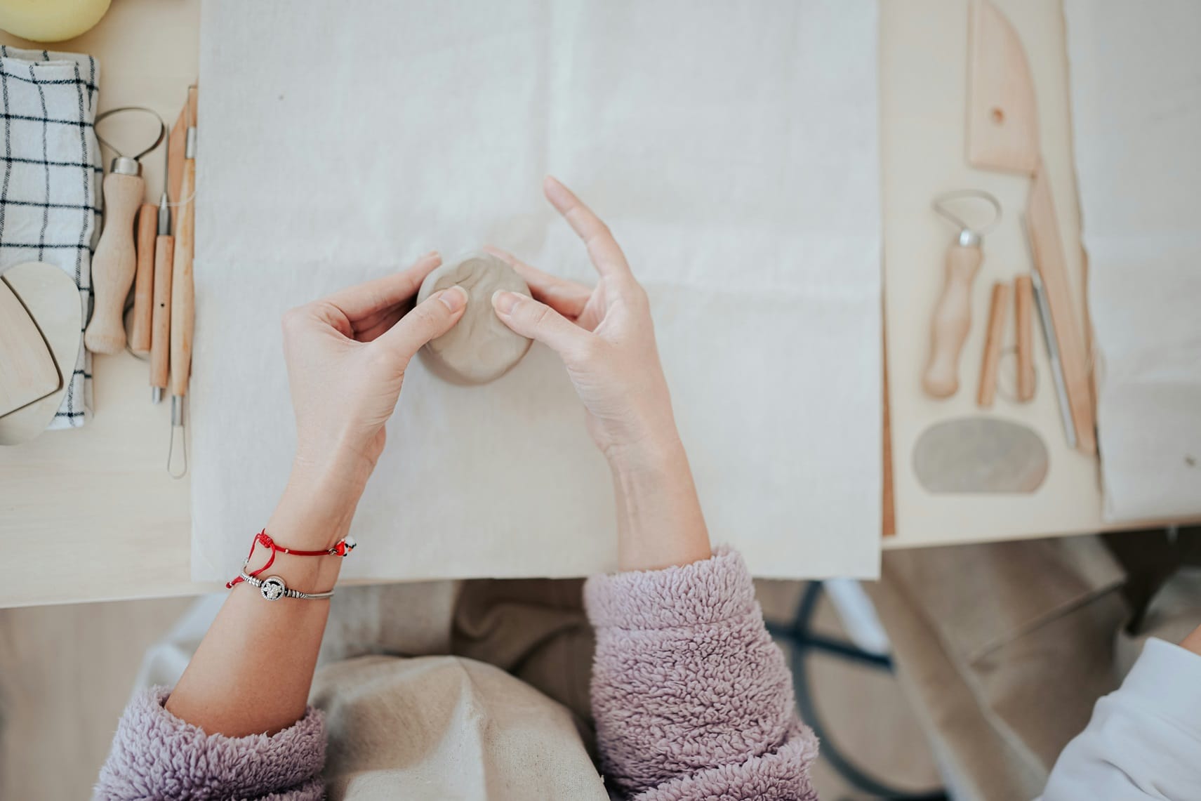 A person working on a clay letter in a studio