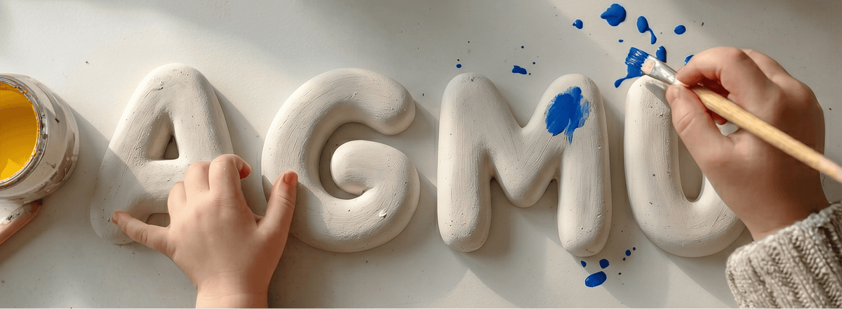 Children's hands working with clay letters on a white surface