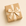 Gift box wrapped in brown paper with a gold ribbon on a beige background