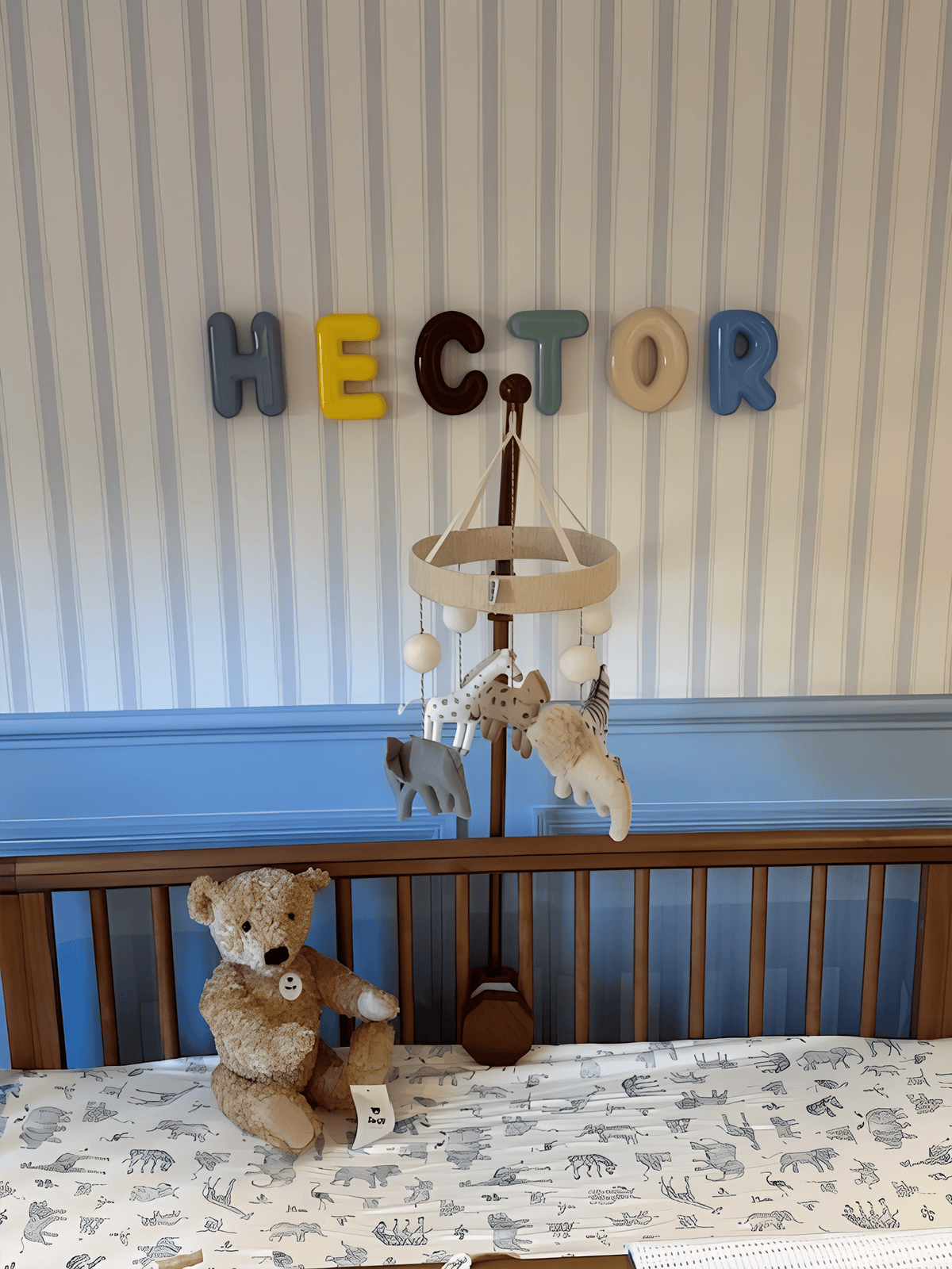 Nursery room with wooden crib, teddy bear, and ceramic &