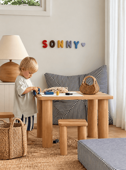 Handcrafted ceramic letters and symbols styled on a playroom wall